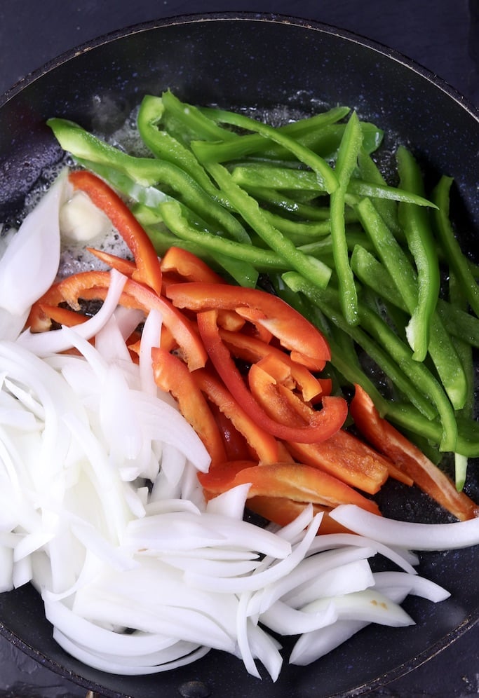 skillet with green & red bell peppers and sliced onions