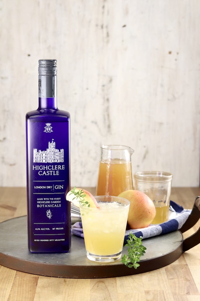 Highclere Castle Gin with apple cider, honey syrup, an apple, fresh thyme and small glass with cocktail