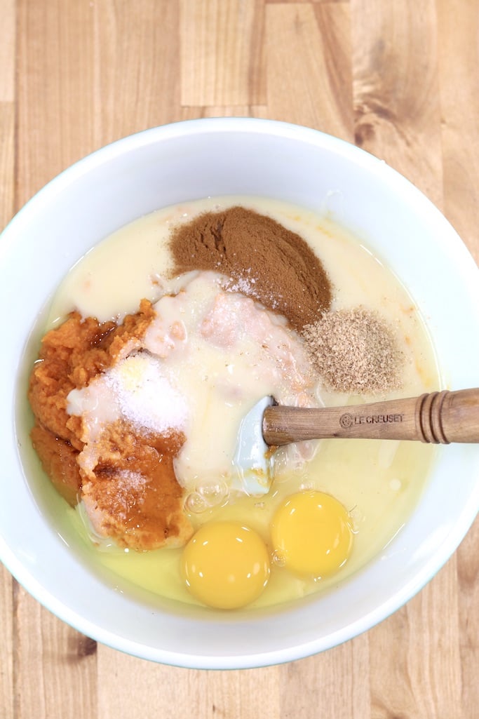 Bowl of pumpkin pie filling with eggs, pumpkin, cinnamon