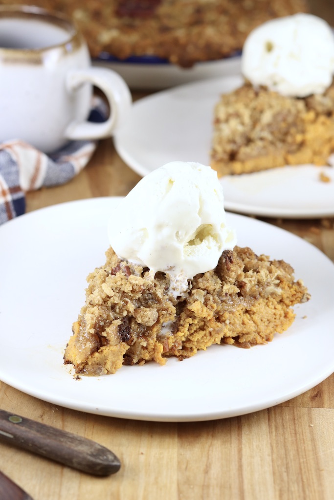 slice of pumpkin pecan crisp dessert with vanilla ice cream scoop on top