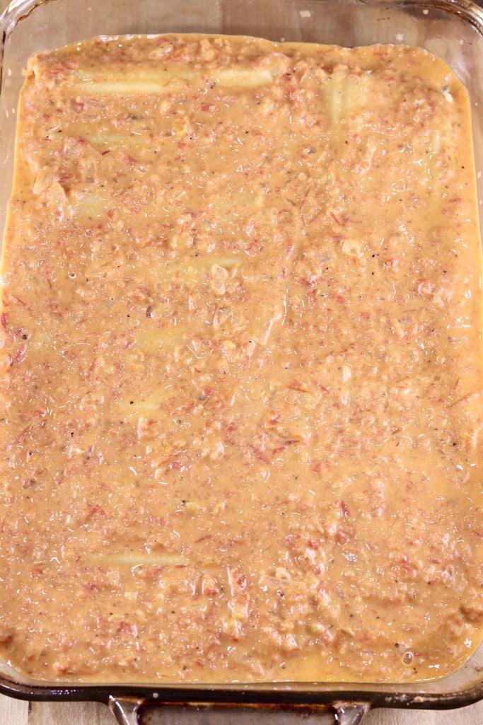 Baking dish with creamy tomato sauce over manicotti