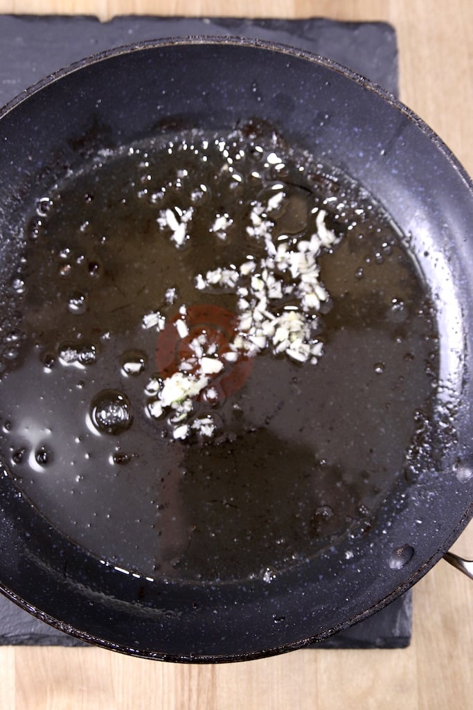 Skillet with bacon drippings and toasted garlic