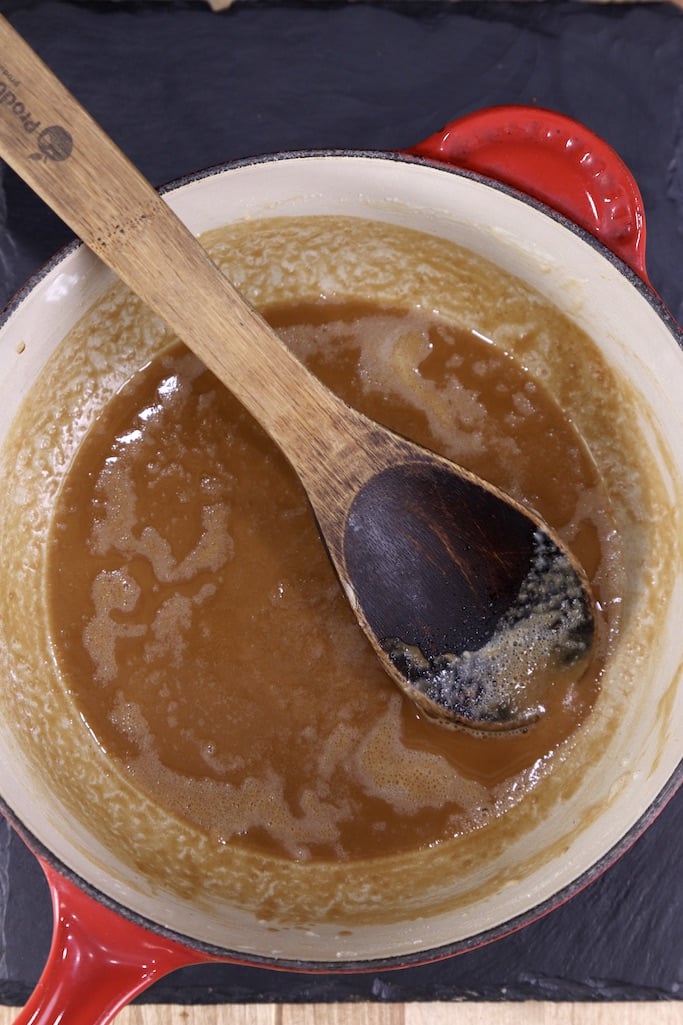 Medium brown roux in a pan with a wooden spoon