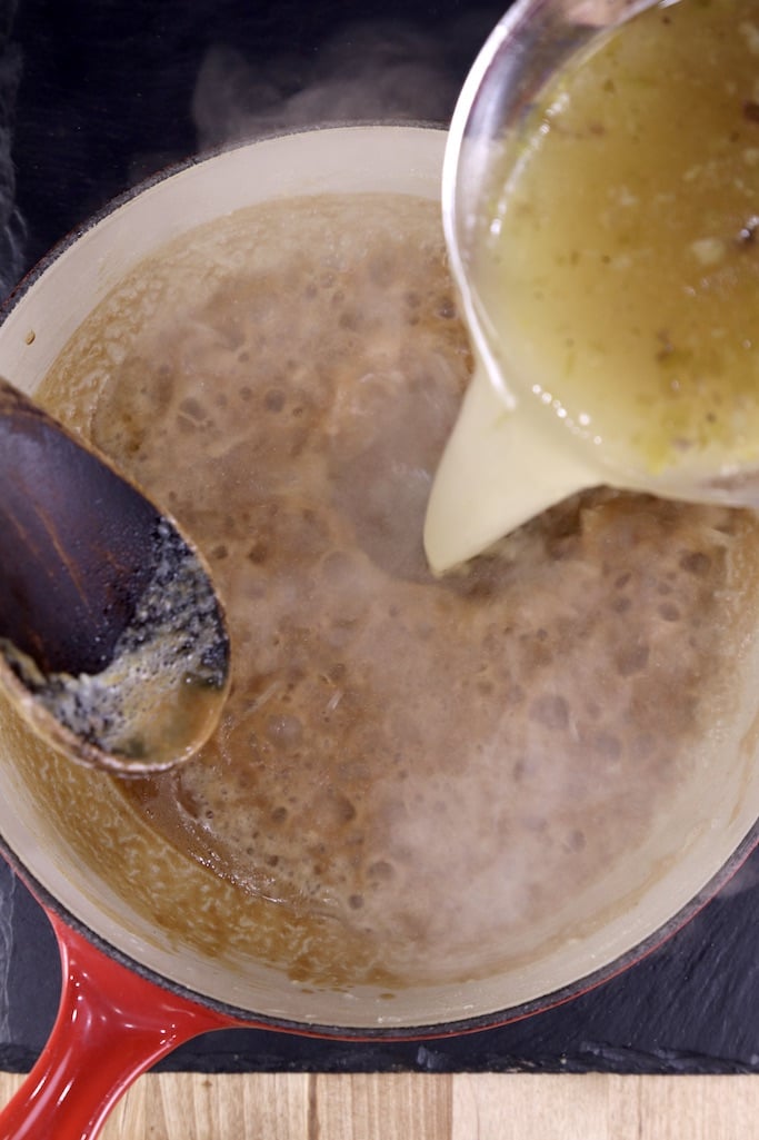 whisking broth into roux for gravy