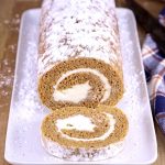 Pumpkin Roll with one slice off on a platter