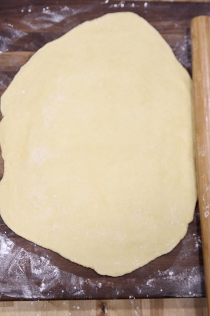 Homemade pasta dough rolled out on a floured board