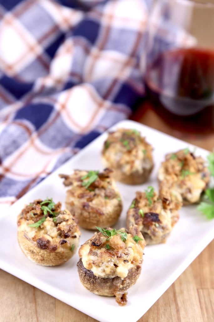 Plate of mushrooms stuffed with cheese and sausage with a plaid napkin