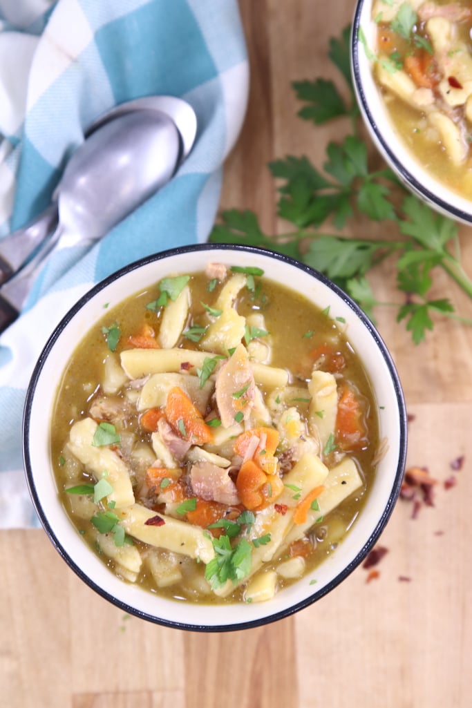Homemade Turkey Noodle Soup overhead view with spoons, blue napkin 