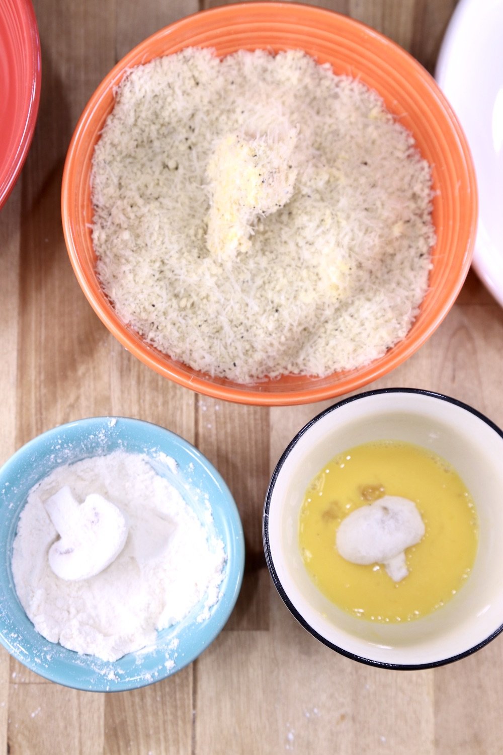 Bowls for breading mushrooms with flour, egg, and panko bread crumb mixture, mushroom in each
