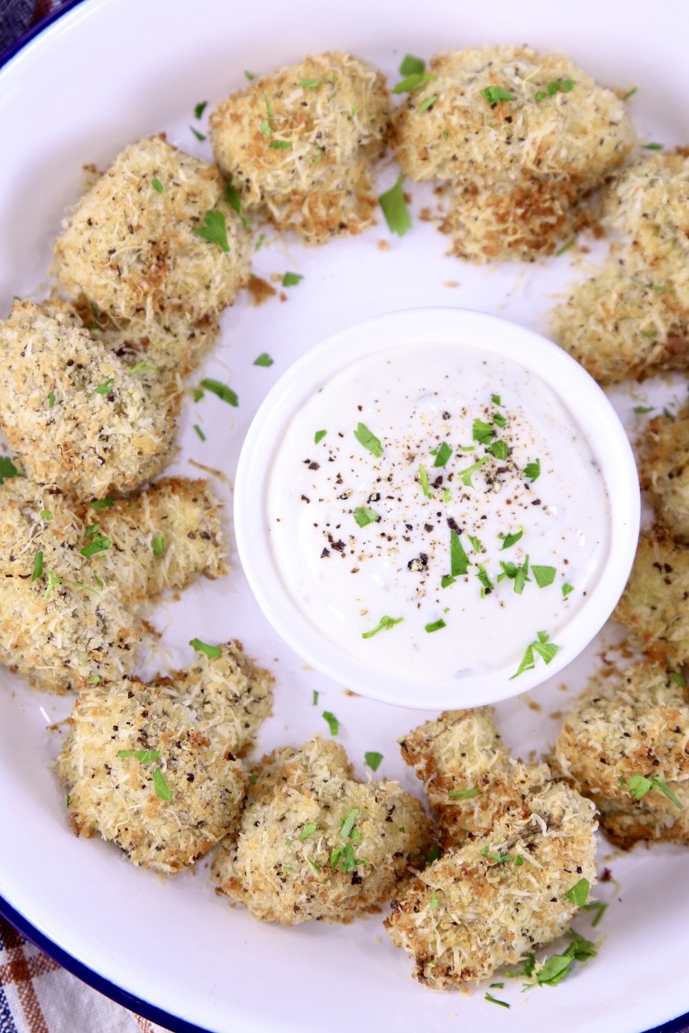 Overhead view of pie plate with breaded mushrooms and ranch dressing