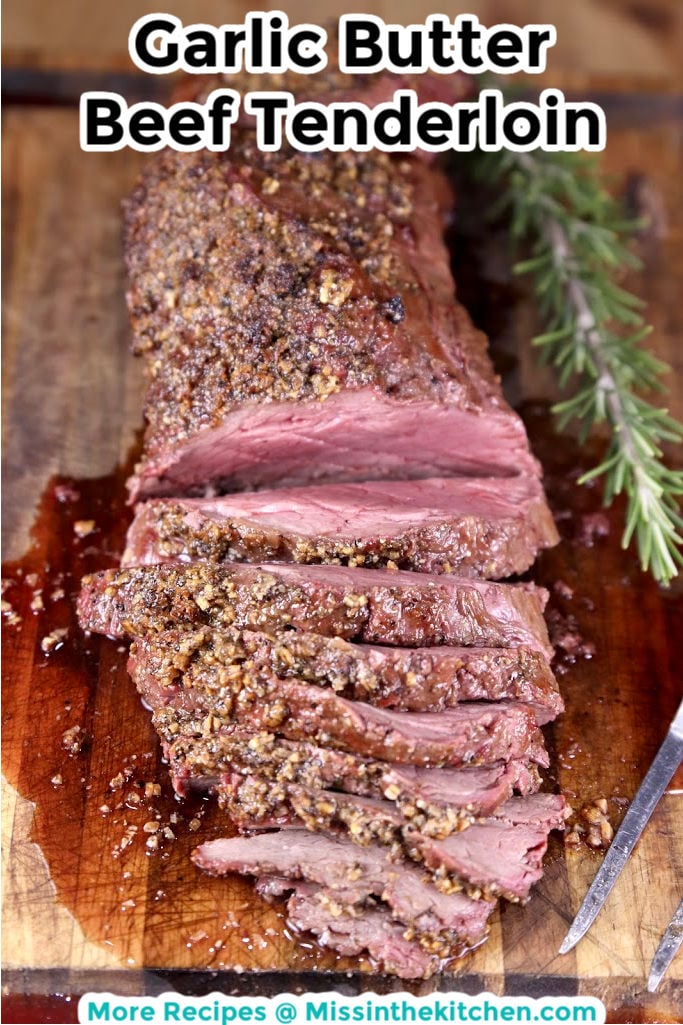 Garlic Butter Beef Tenderloin partially sliced on a cutting board - text overlay