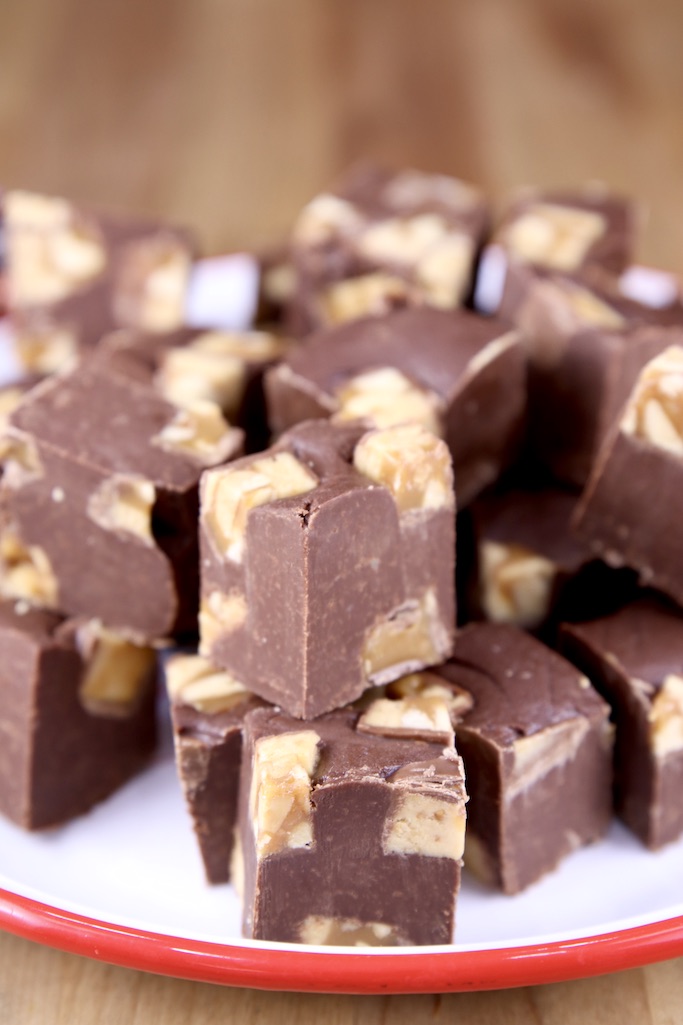closeup of Snickers fudge, stacked on a red rimmed plate