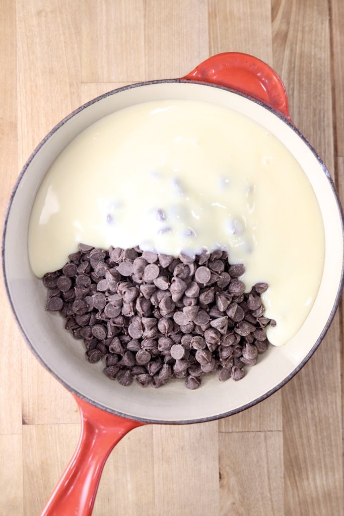 Red saucepan with chocolate chips and sweetened condensed milk