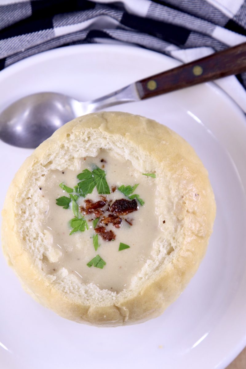 Bread Bowl filled with soup on a plate with a spoon