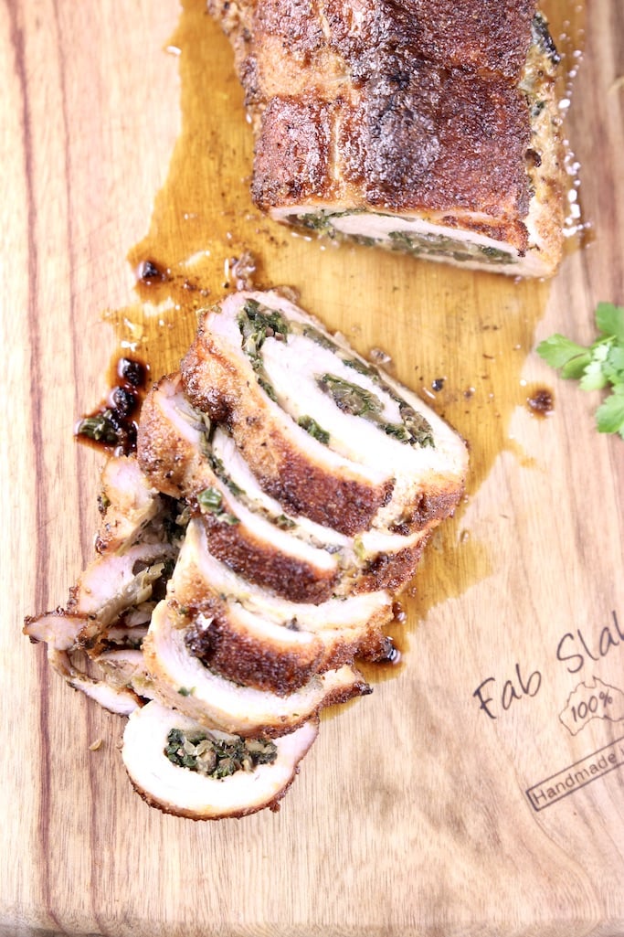 Sliced stuffed pork tenderloin on a cutting board