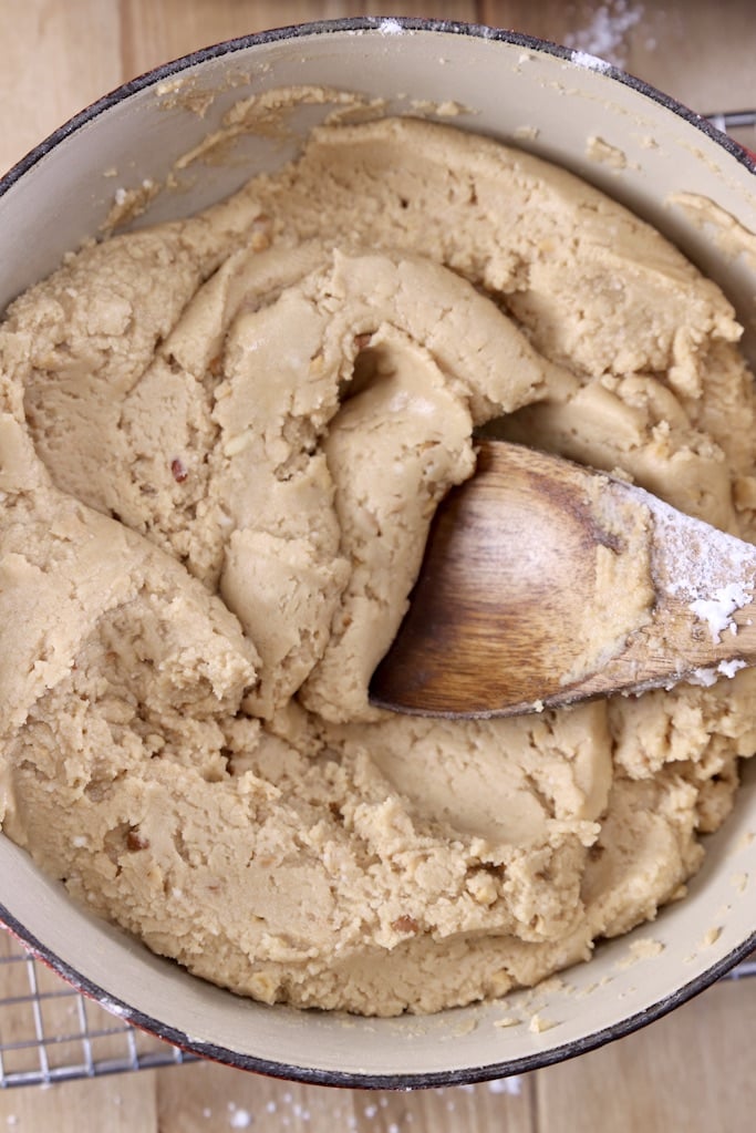 Peanut butter fudge in a saucepan with wood spoon