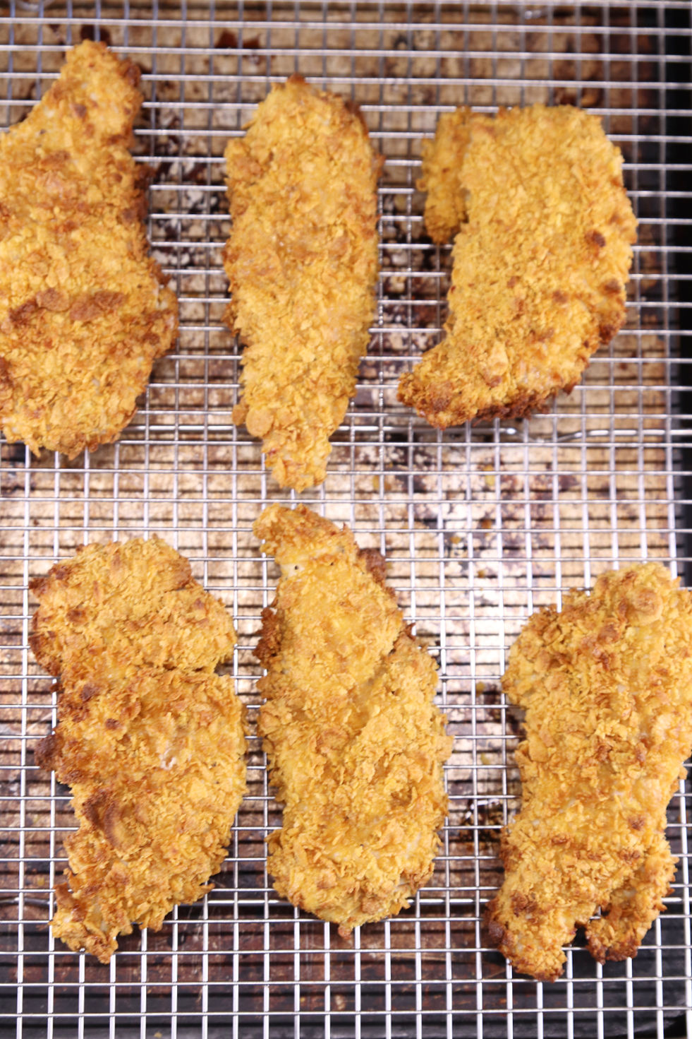 Breaded Chicken Strips on a wire rack lined baking sheet