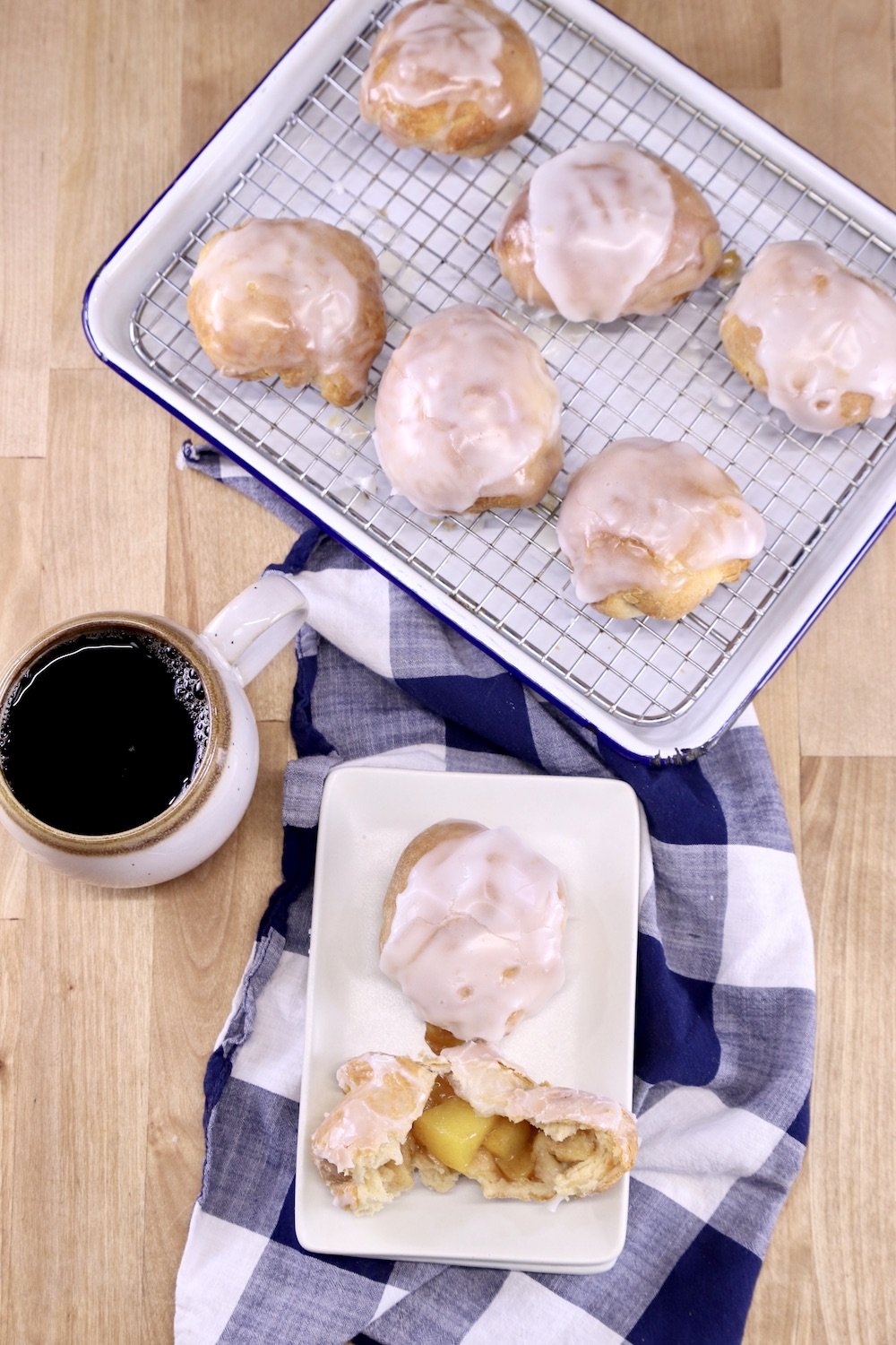 tray of peach cobbler bombs, 2 on a dessert plate, cup of coffee