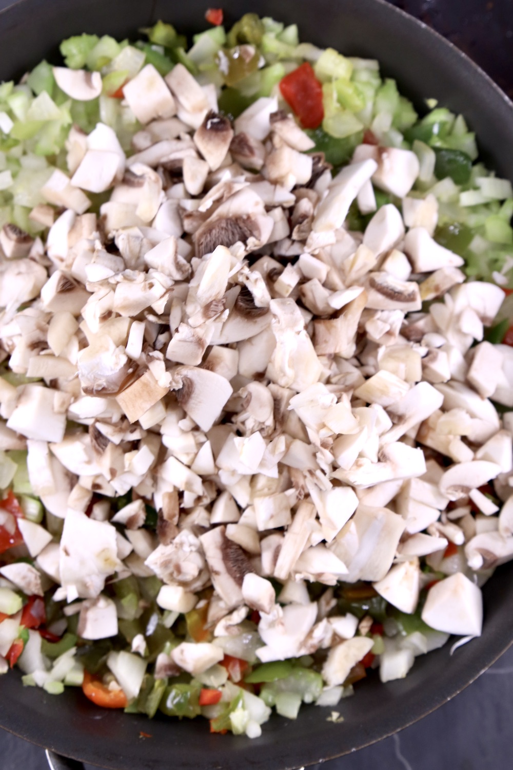 diced mushrooms added to pan of onions, celery, bell peppers