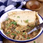 Bowl of crawfish pie with crust. Spoon in the bowl.