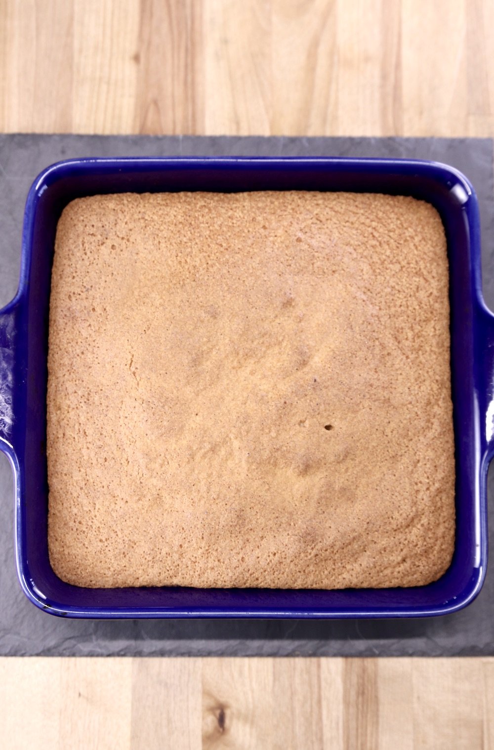 baked pineapple upside down cake in a blue square baking dish