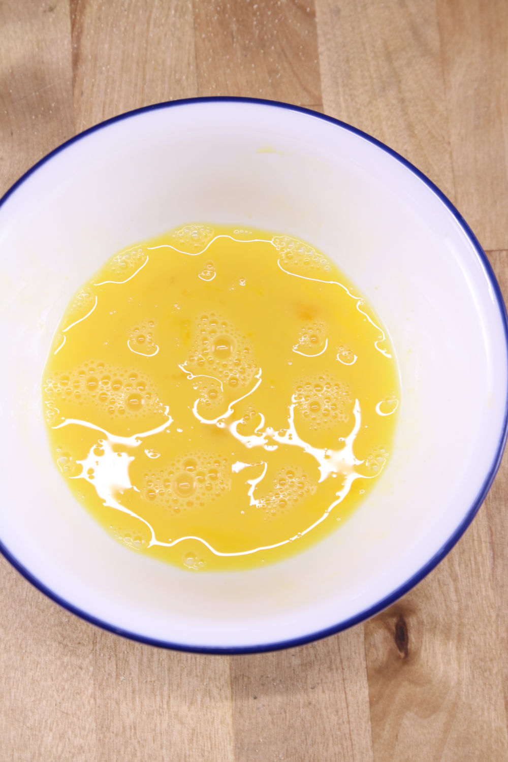 white bowl with 2 beaten eggs for chicken batter