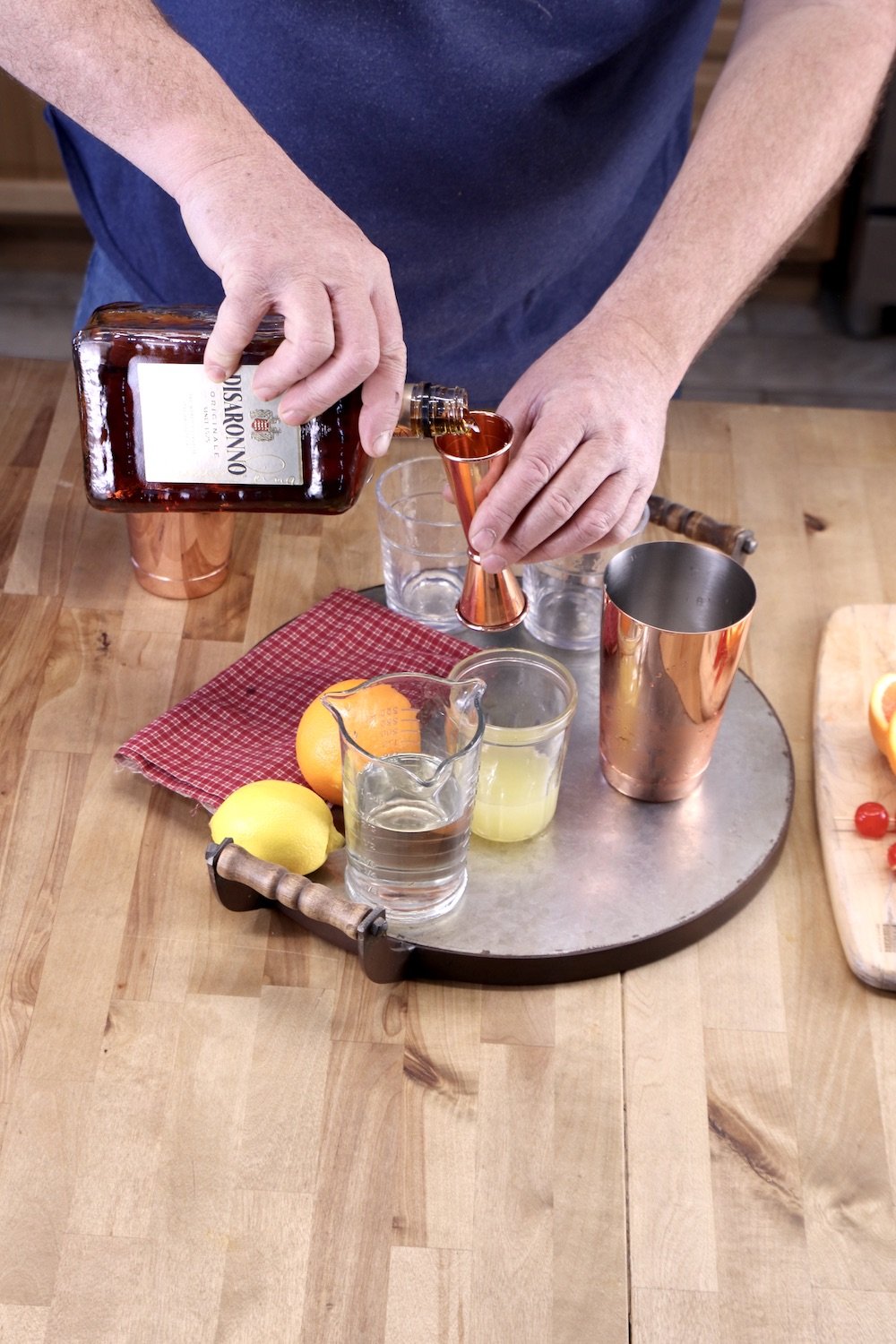 man pouring amaretto into a jigger