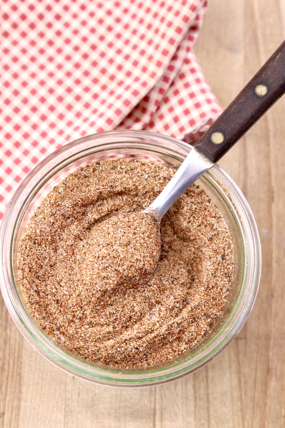 Chili Seasoning in a glass jar with spoon, red check napkin