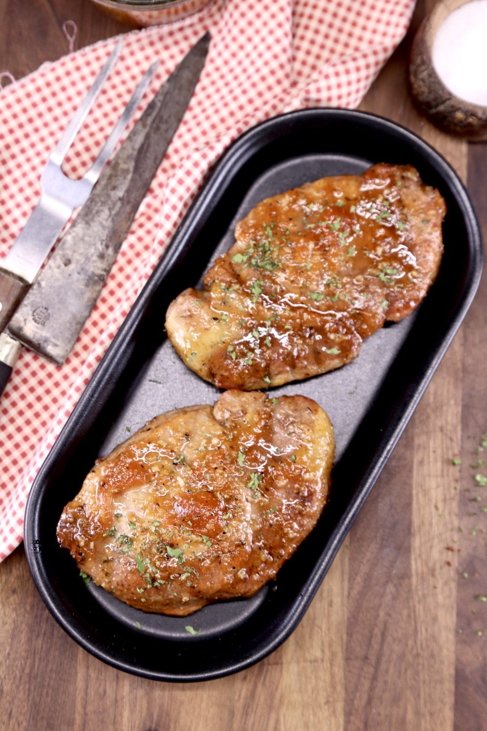 black platter with 2 apricot pork chops