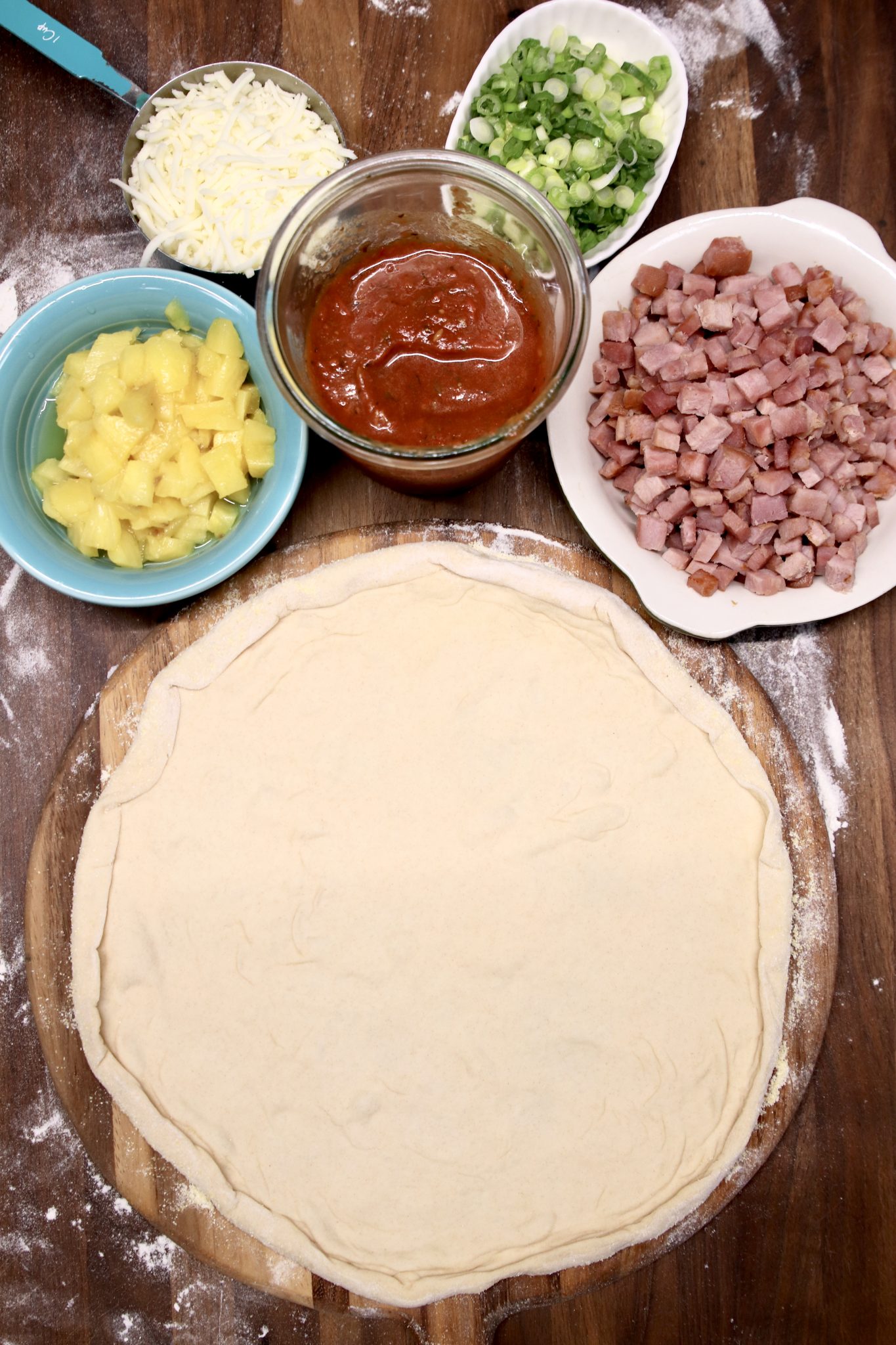 pizza dough with toppings in bowls