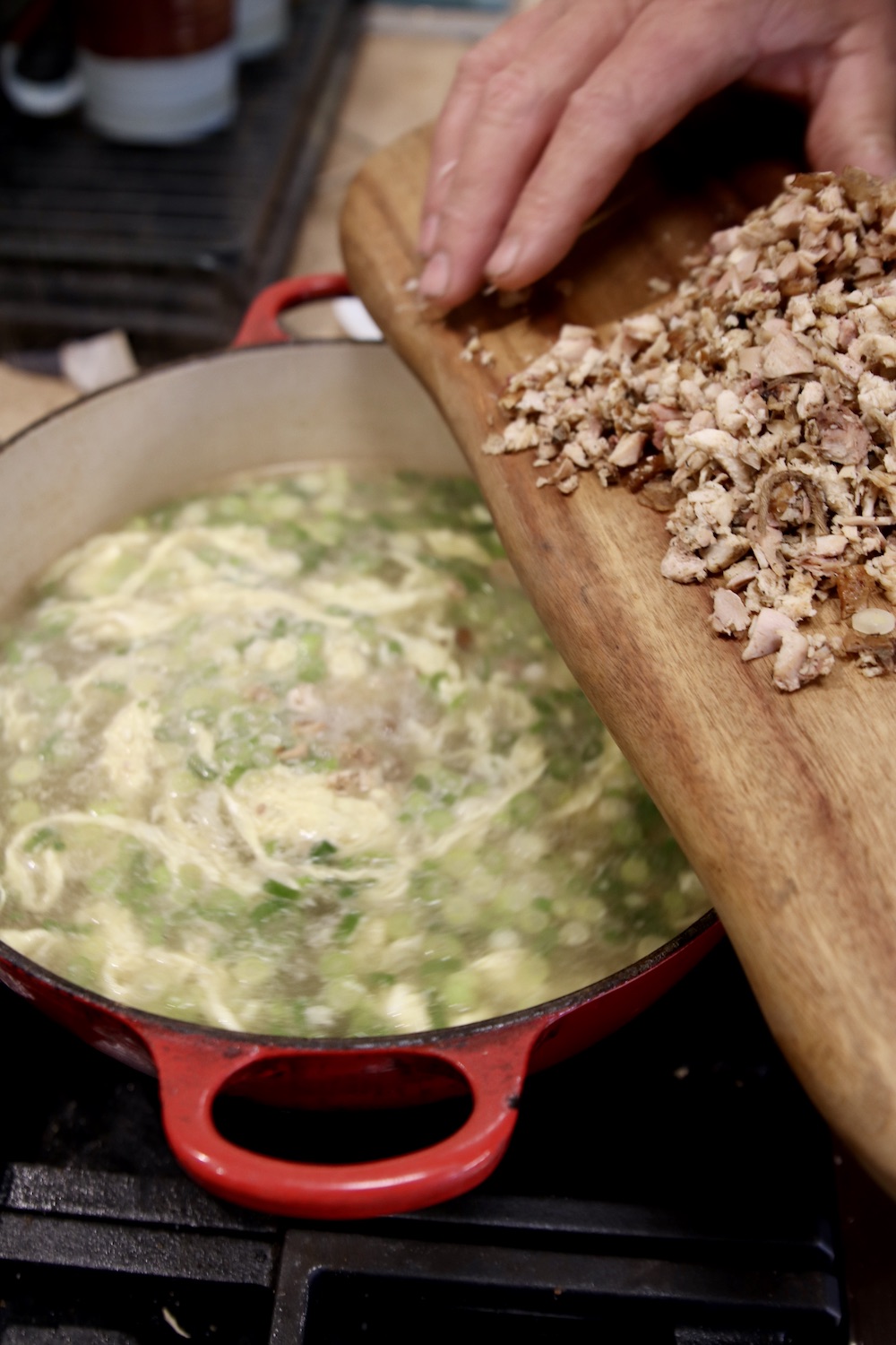 adding diced chicken to soup