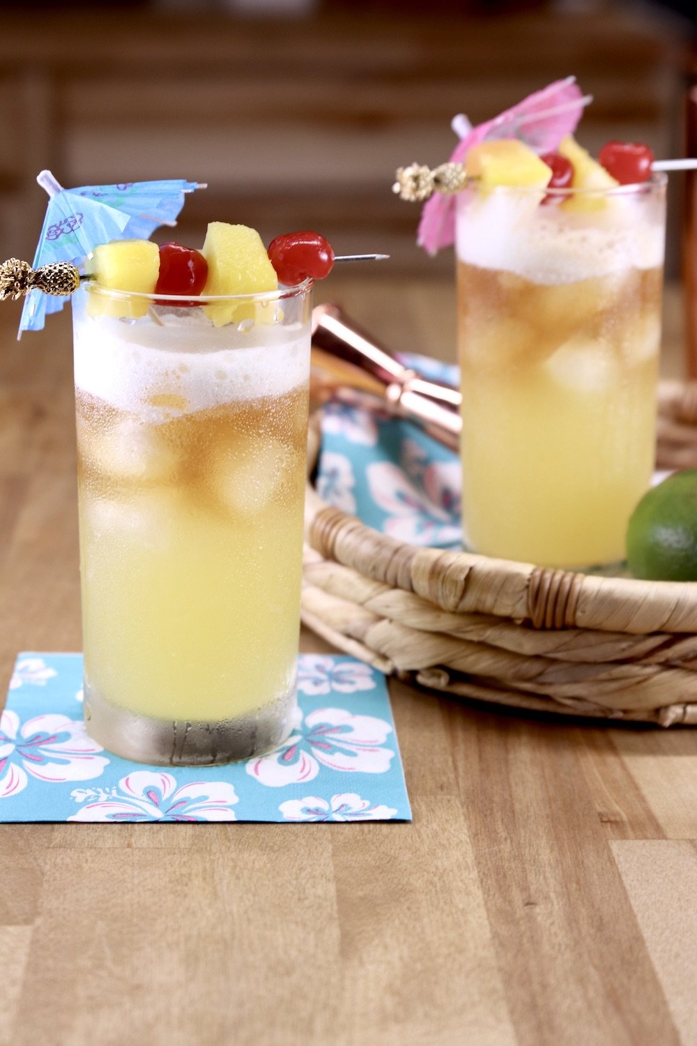 2 Mai Tai cocktails garnished with pineapple and cherries