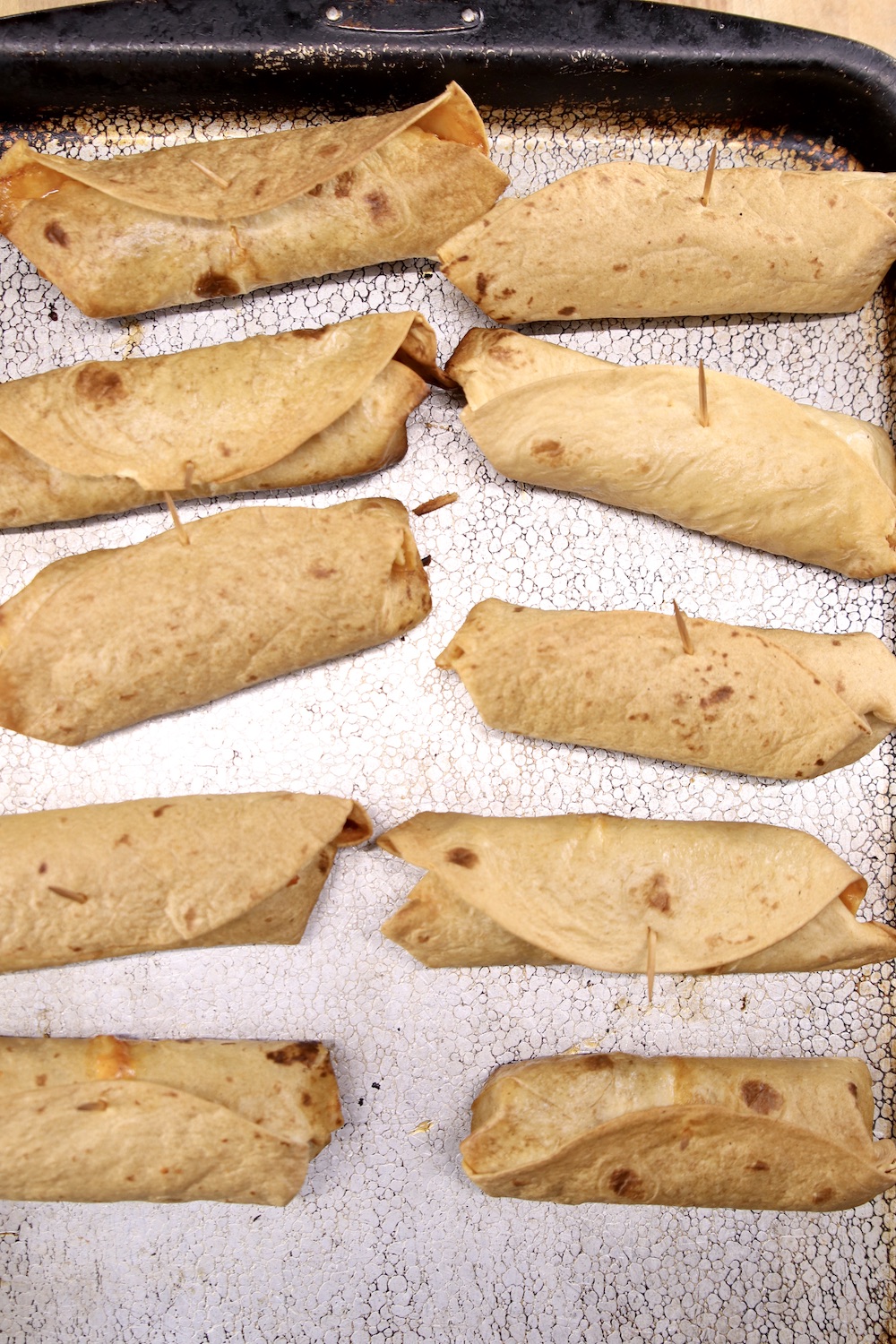 Cooked beef burritos on a sheet pan