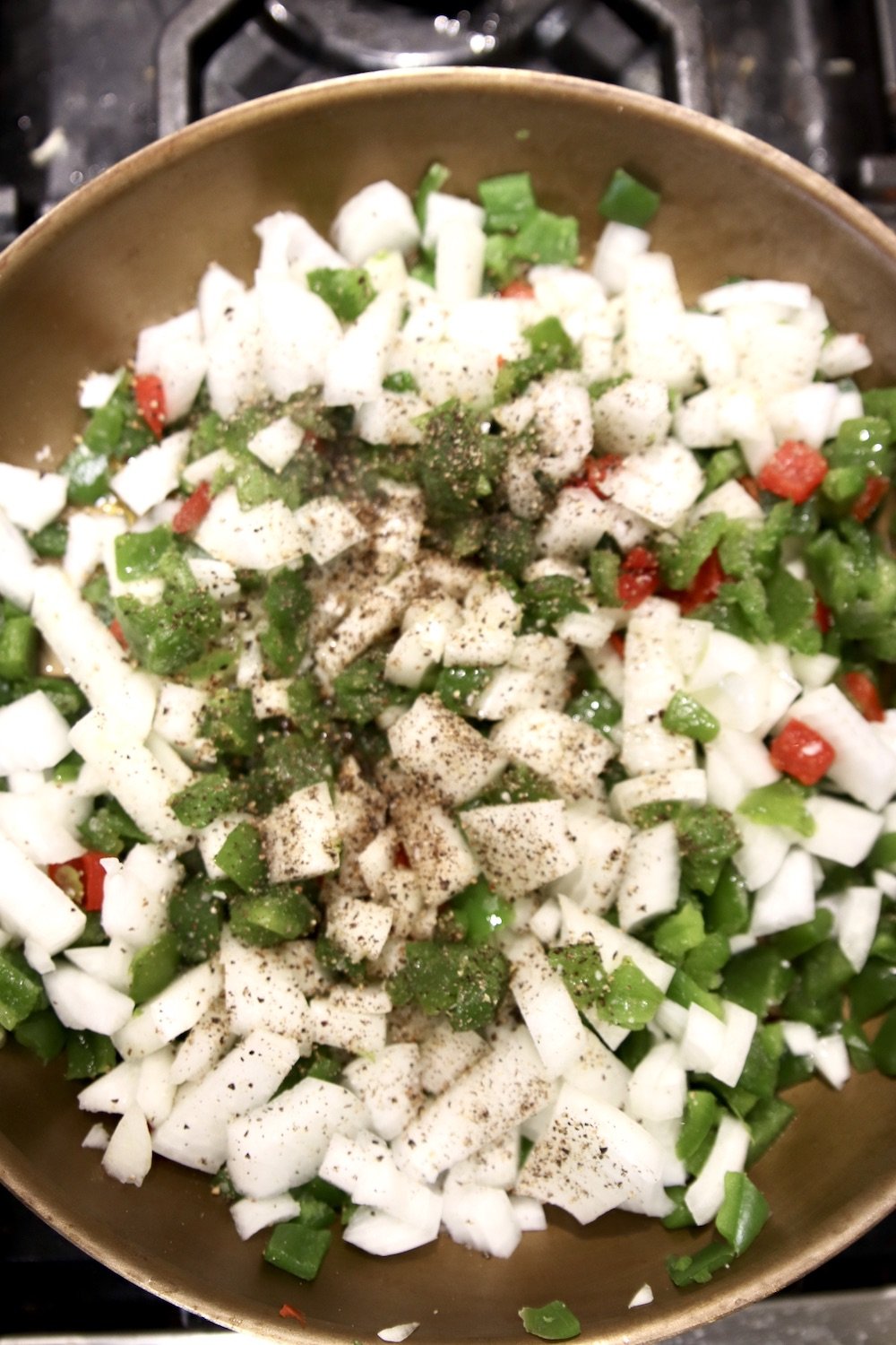 skillet with diced onions and peppers, salt & pepper