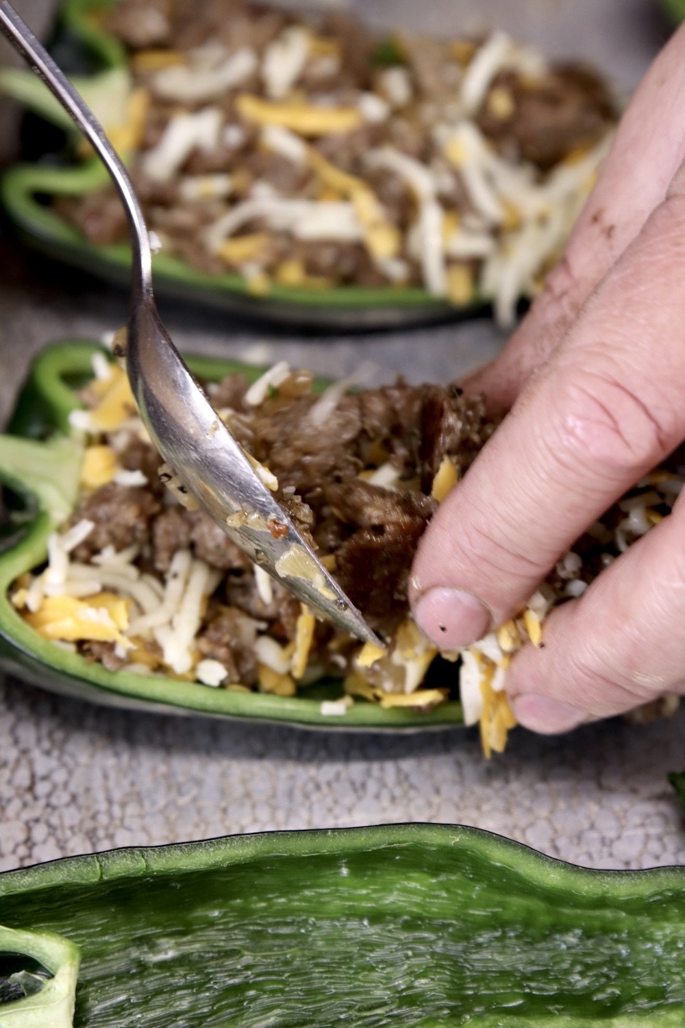 spooning sausage into poblano peppers