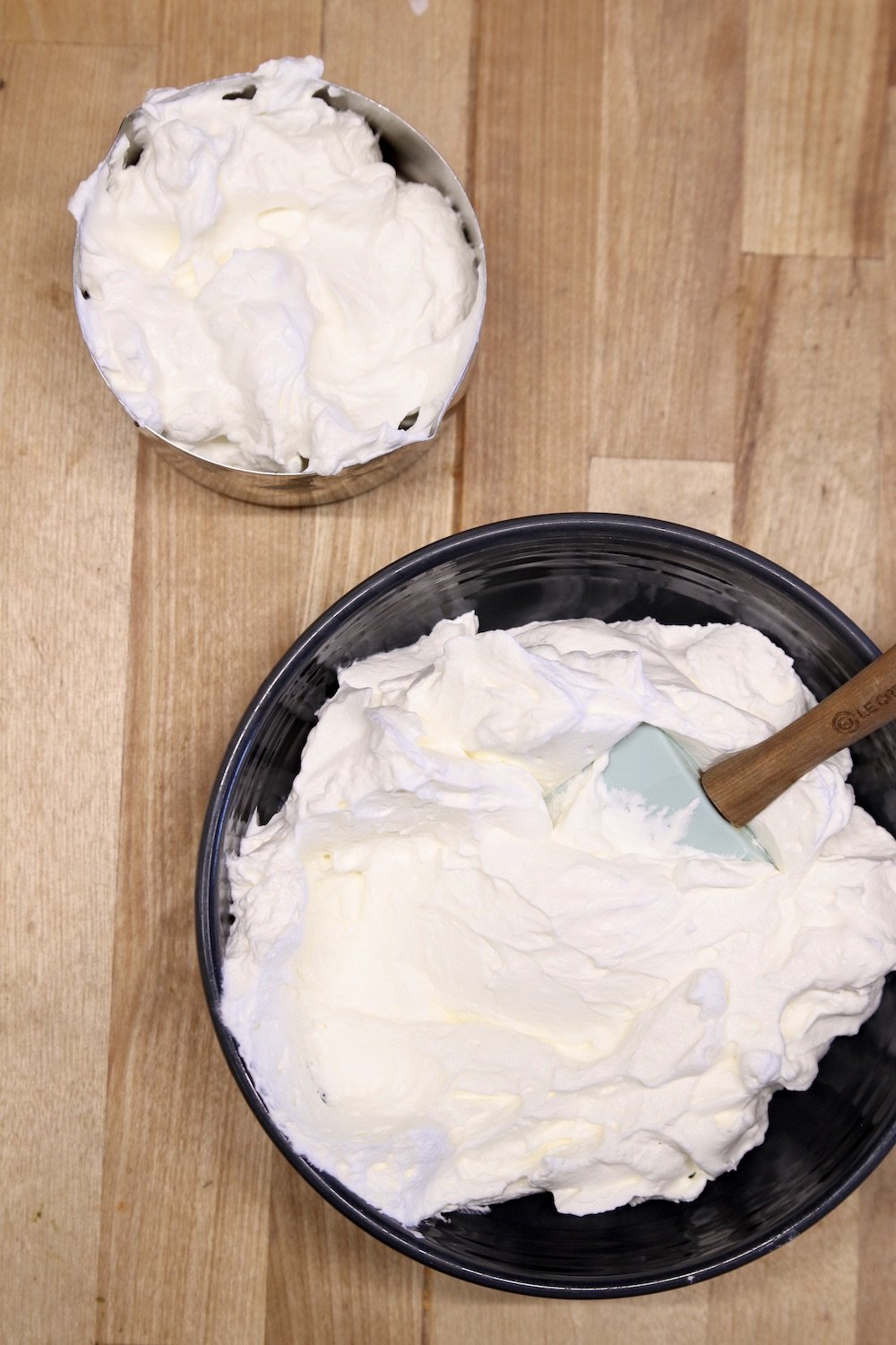 bowl of whipped cream and measuring cup of whipped cream