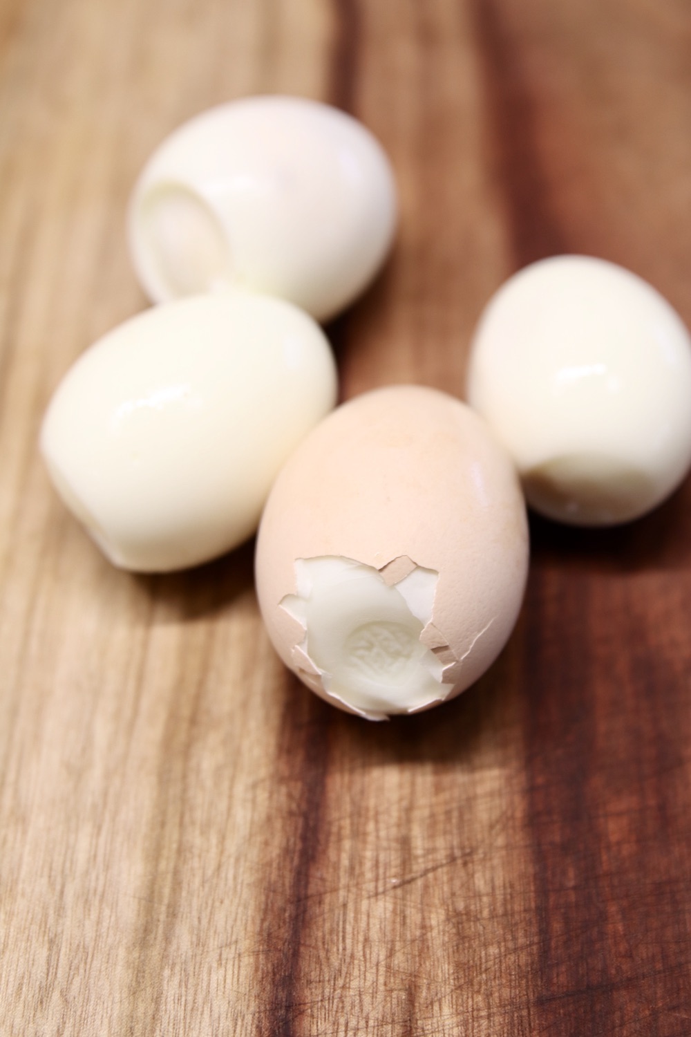 peeled eggs, one with shell cracked on the end