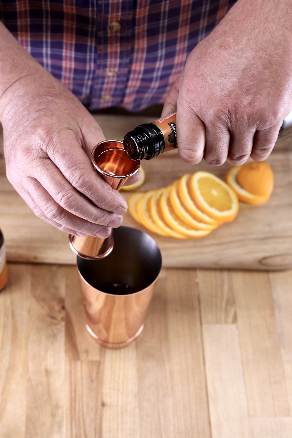 pouring triple sec into a jigger