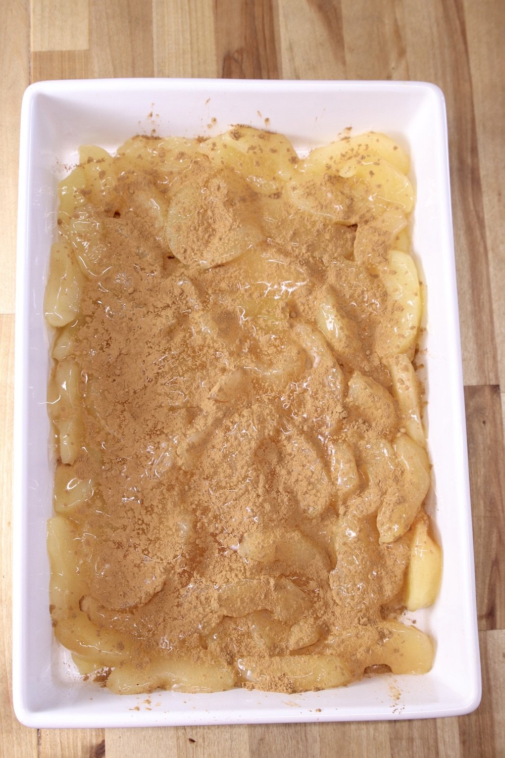 cinnamon sprinkled over apple pie filling