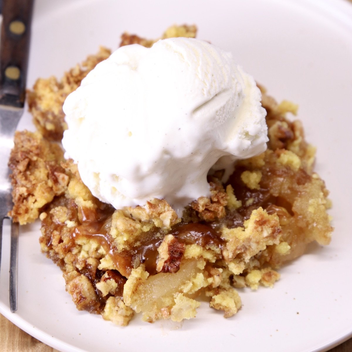 apple dump cake on a plate with ice cream.