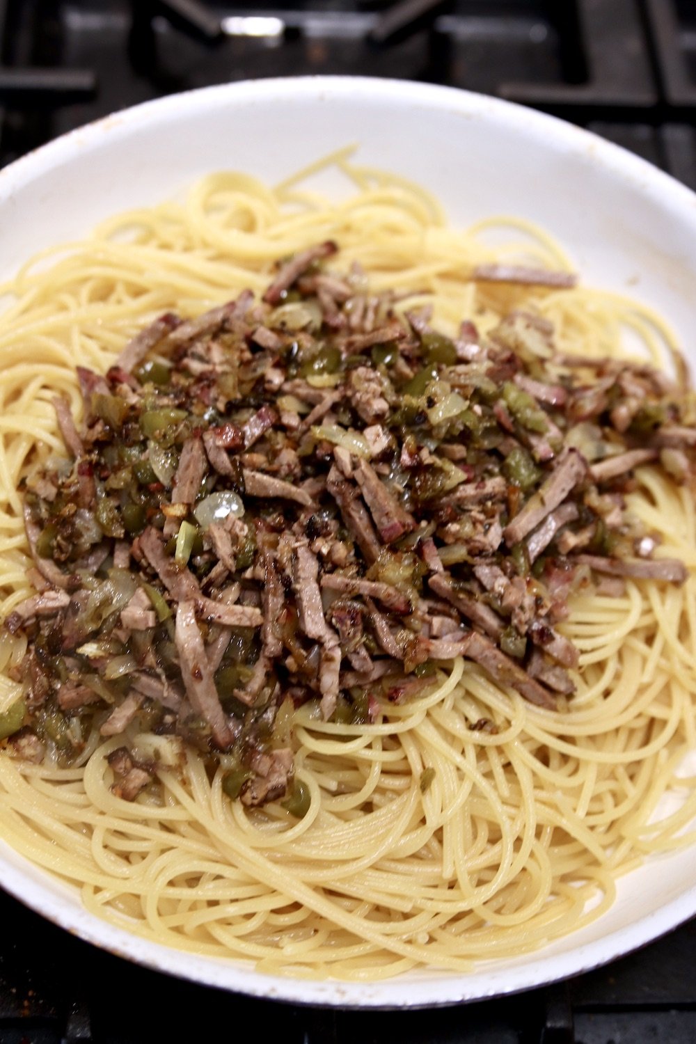 spaghetti topped with chopped brisket and onions