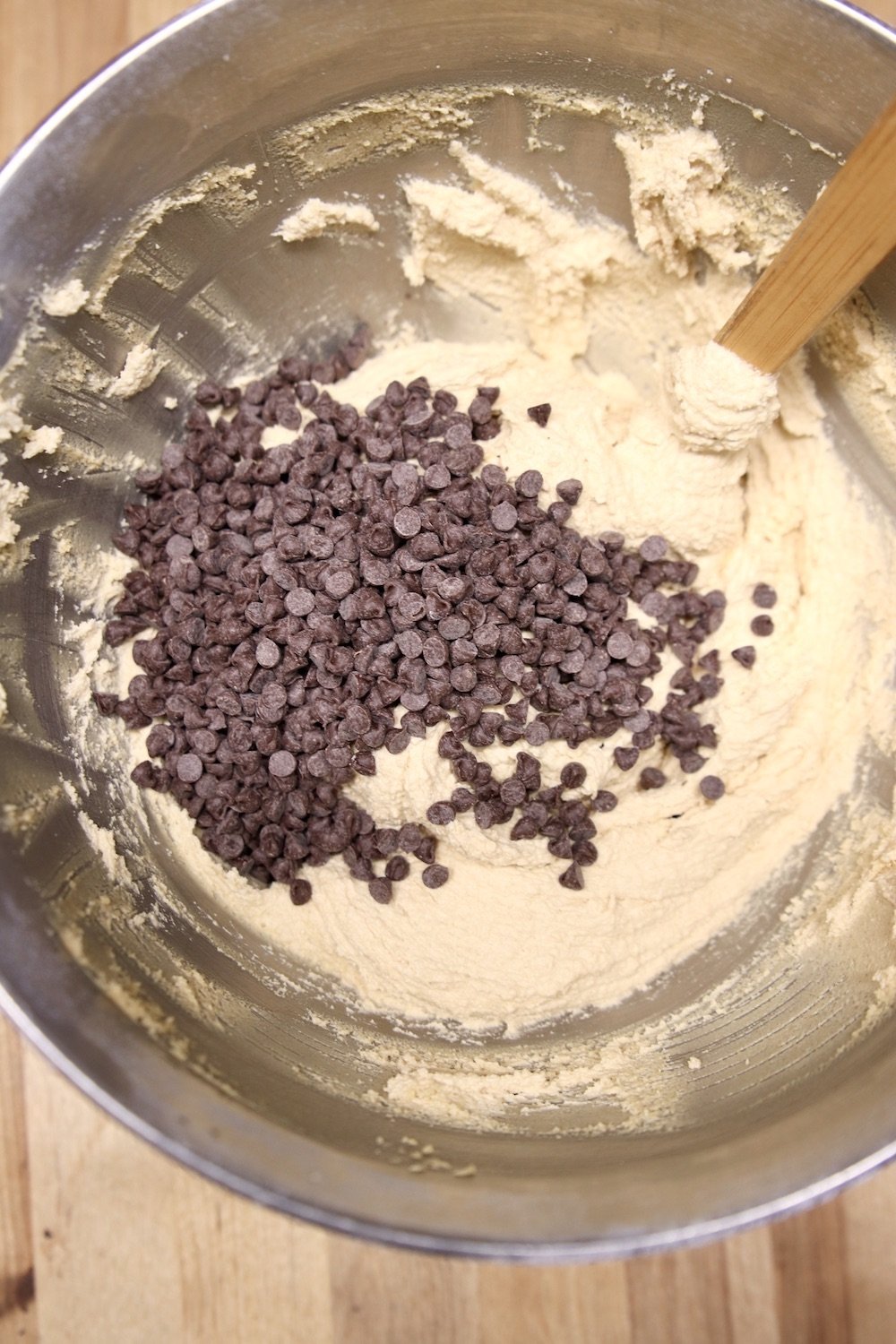 adding chocolate chips to cookie dough