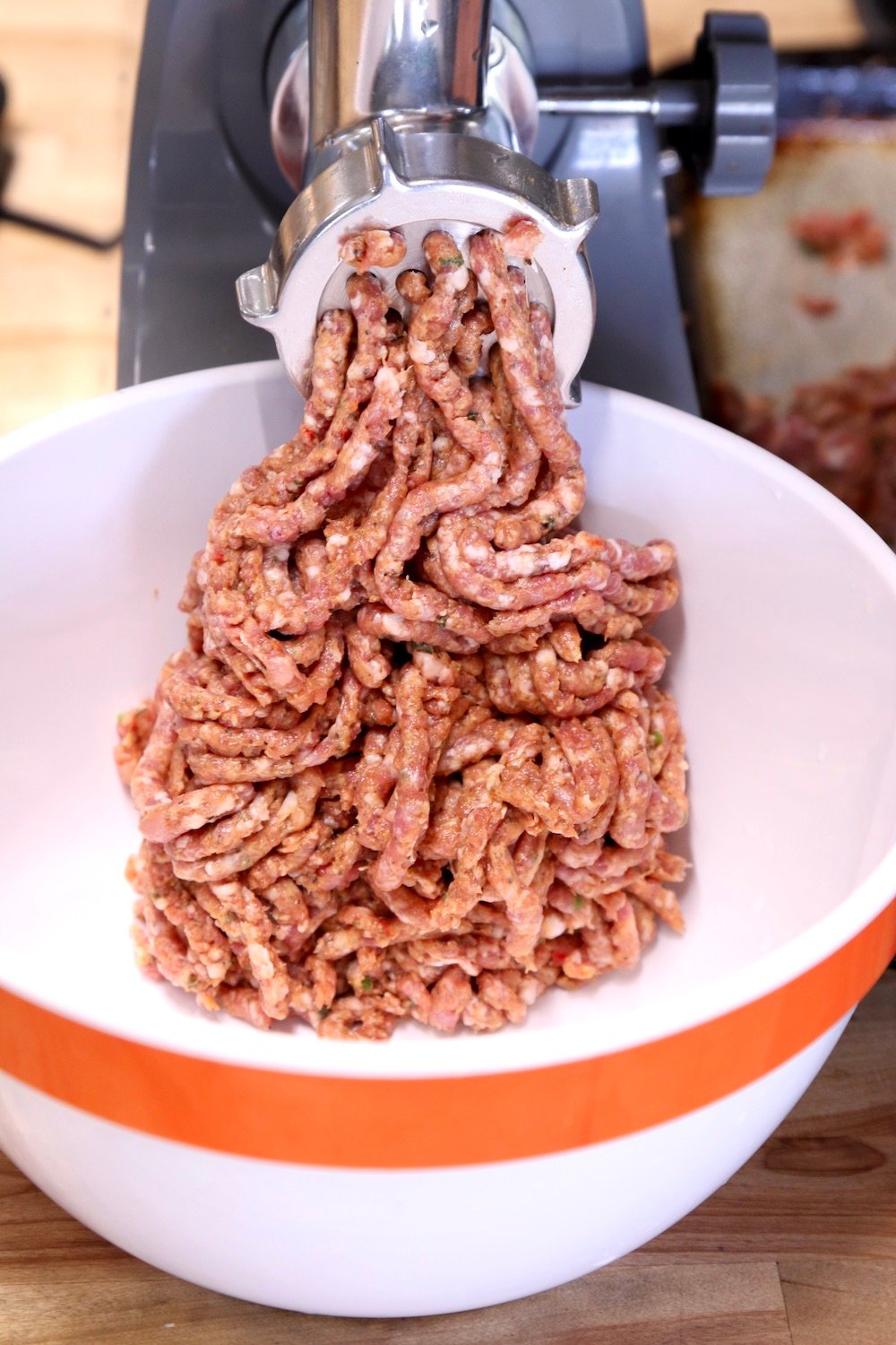 grinding sausage mixture into a bowl