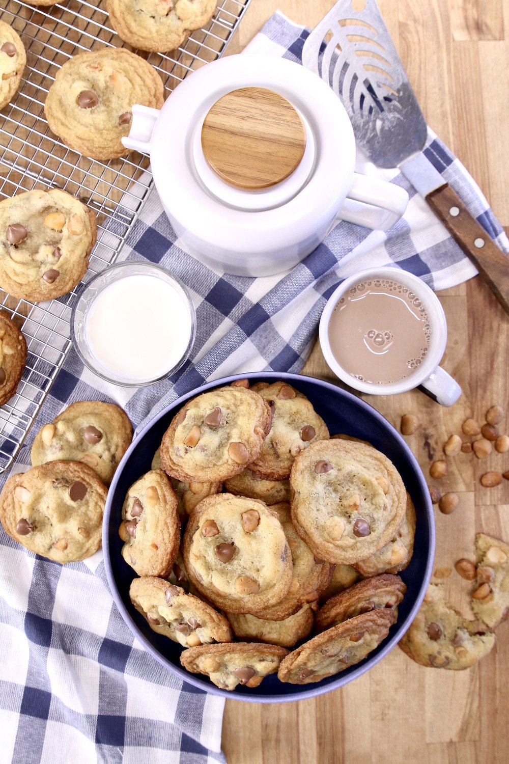 chocolate chip cookies in a bowl, tea pot, glass of milk, mug of hot chocolate