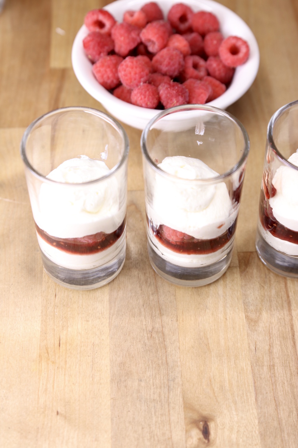 Making layered cheesecake dessert in small glasses