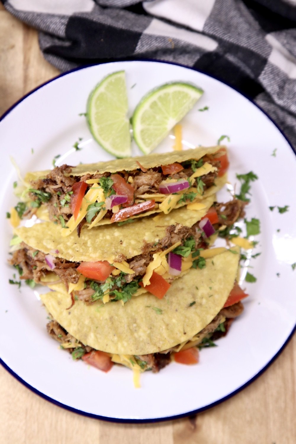 plate of 3 tacos with slices of lime