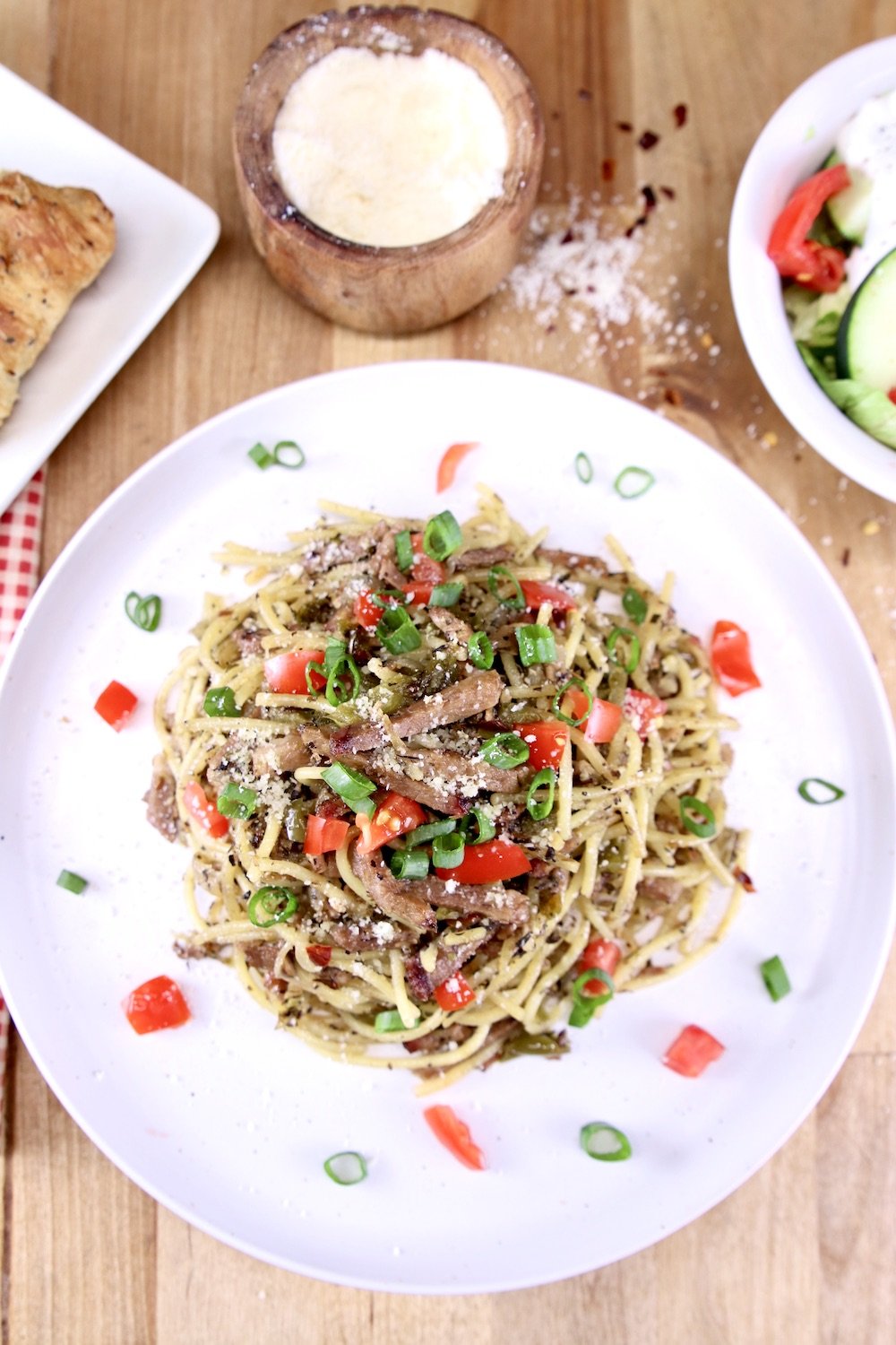 Brisket Spaghetti on a plate, bowl of salad, parmesan cheese