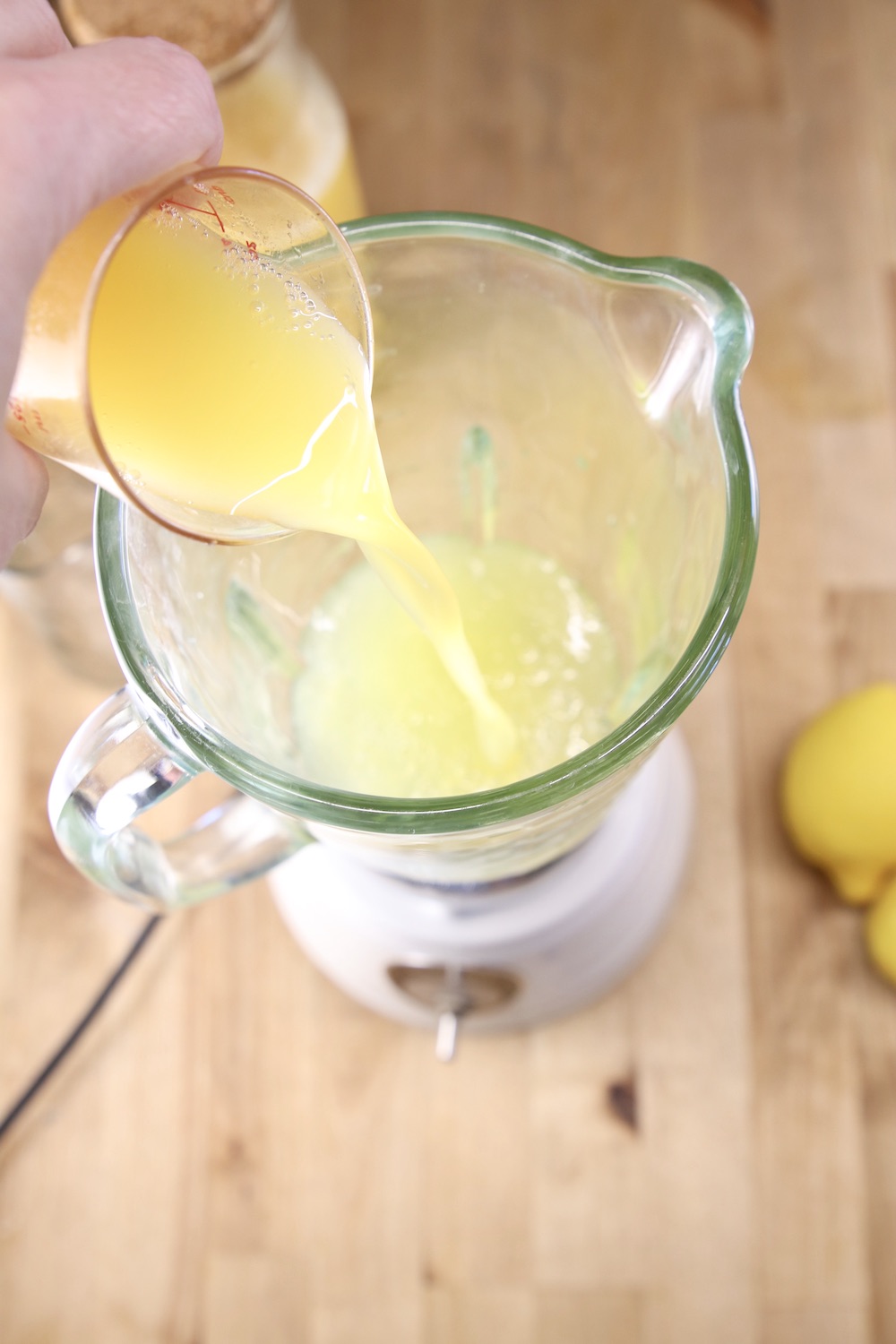 adding pineapple juice to a blender