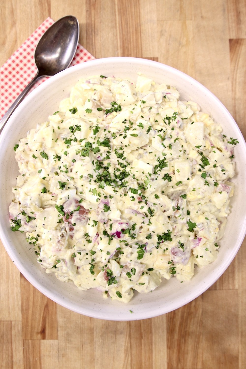 bowl of potato salad, red napkin and spoon to the side