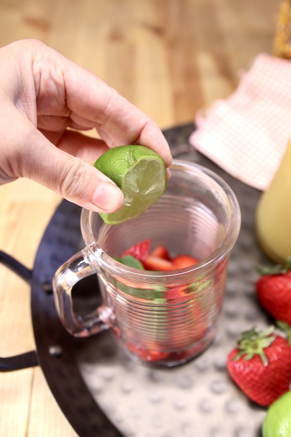 squeezing lime juice into a glass to make mojito